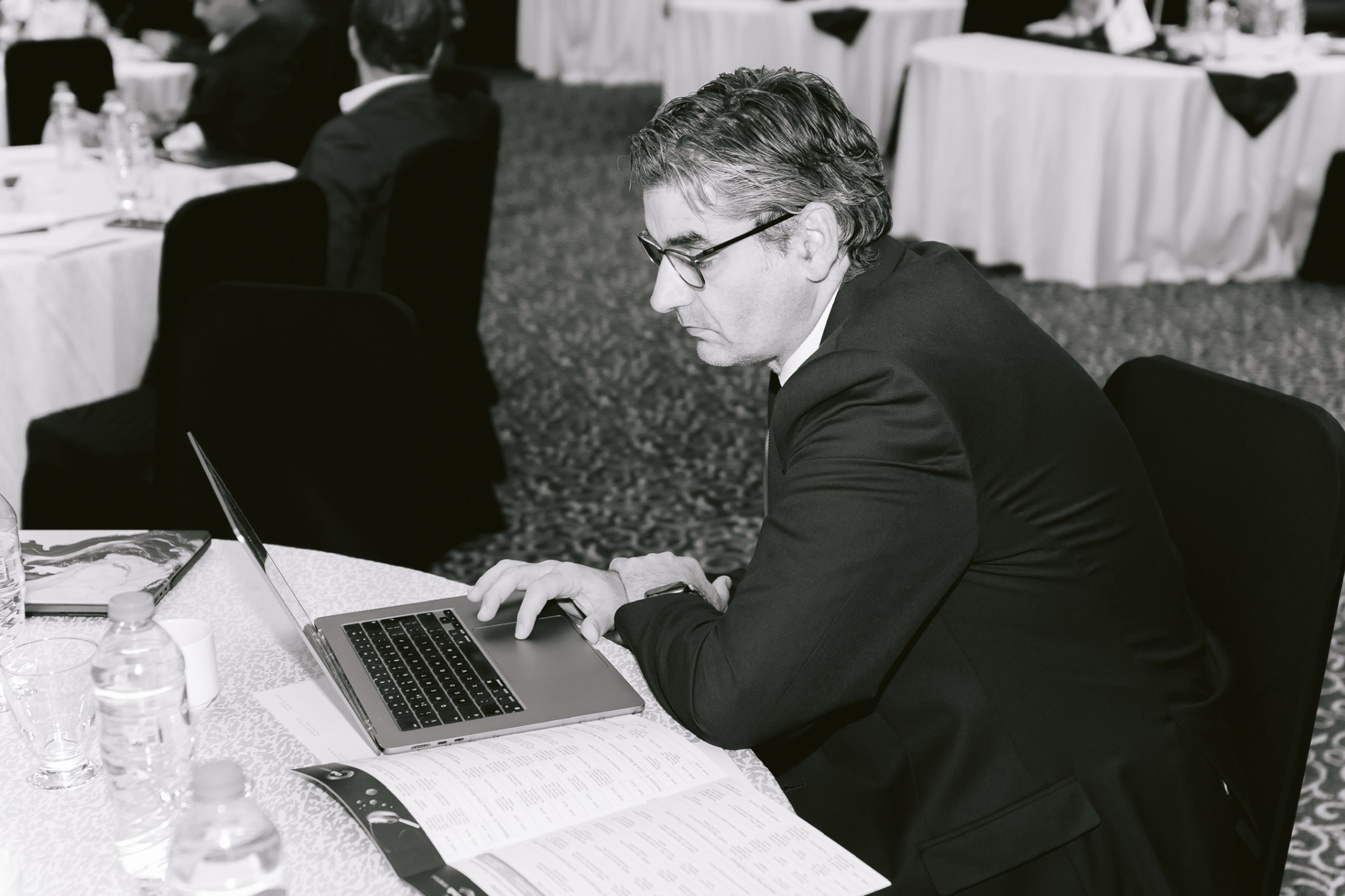 Professor Athanasios Diamantopoulos working at a laptop during a professional meeting